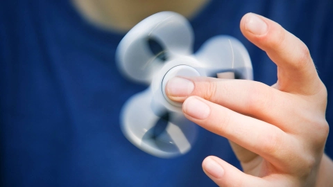 Finger wirbeln einen Handkreisel (Fidget Spinner) umher.