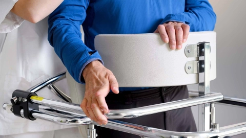 Person mit Gehilfe, unterstützt von einer medizinischen Fachkraft.