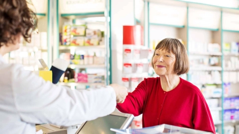 A woman buying medication in a pharmacy.