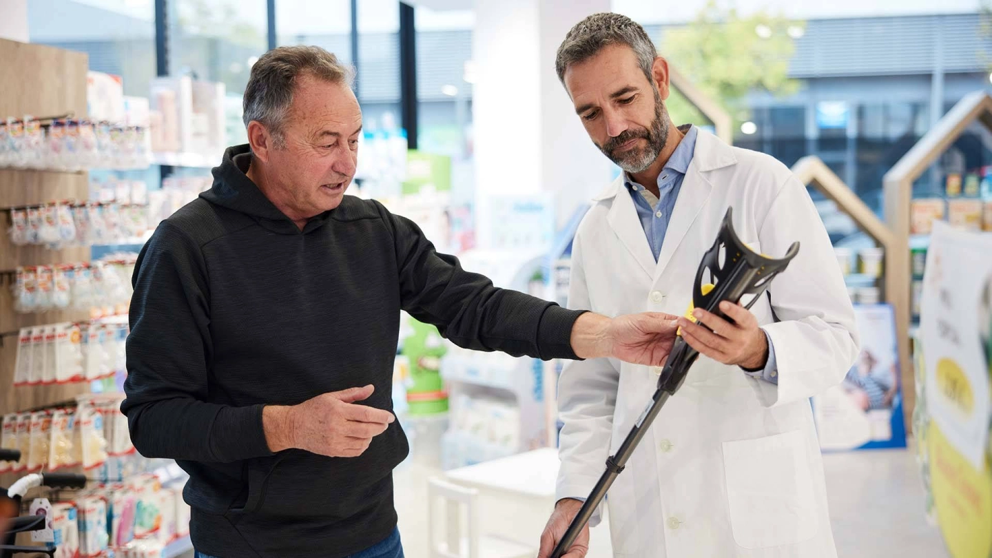 A salesperson and a customer with a walking aid.