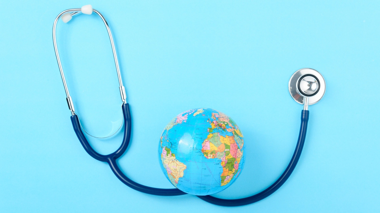 Das Bild zeigt ein Stethoskop und einen Globus.