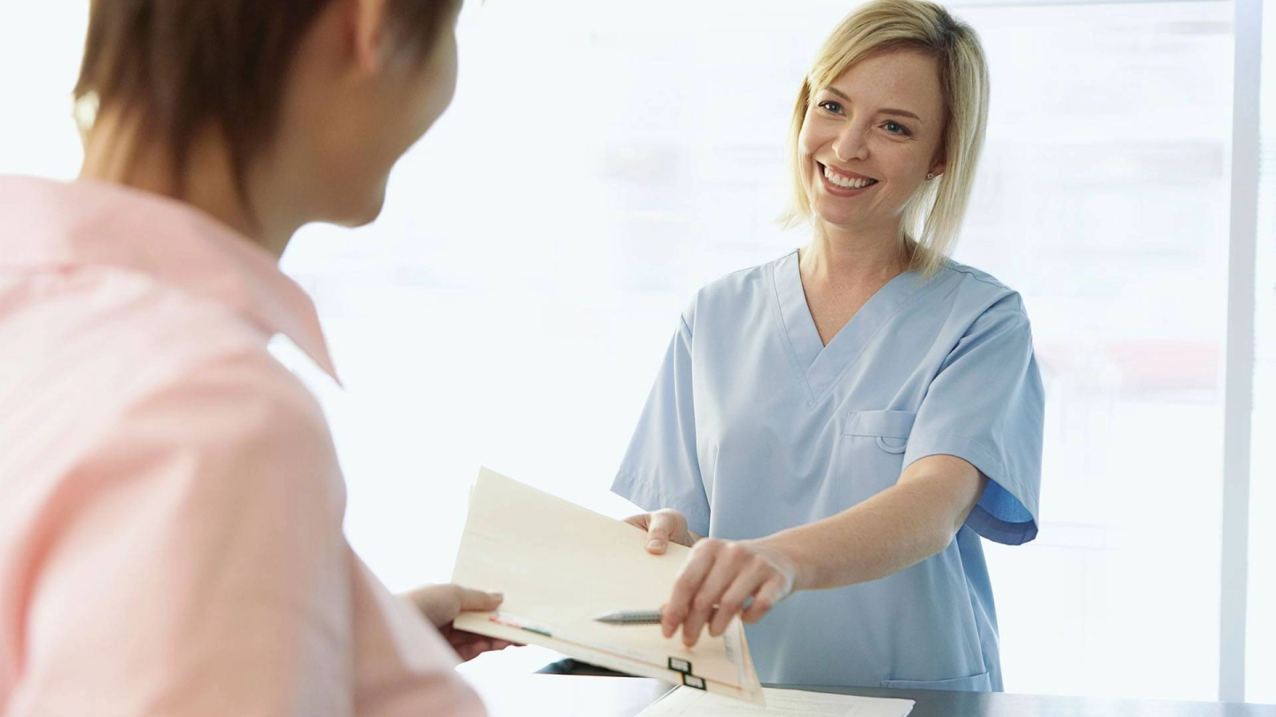 امرأة تُسلم وثيقة إلى امرأةٍ أخرى