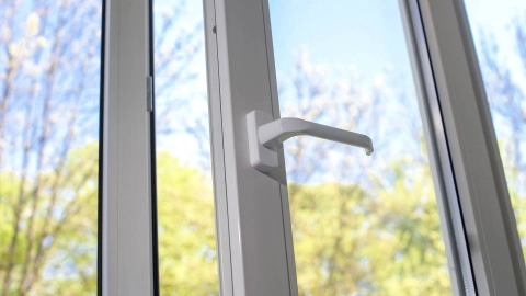 Ein Fenster steht offen. Im Hintergrund sind Bäume und ein blauer Himmel zu sehen.