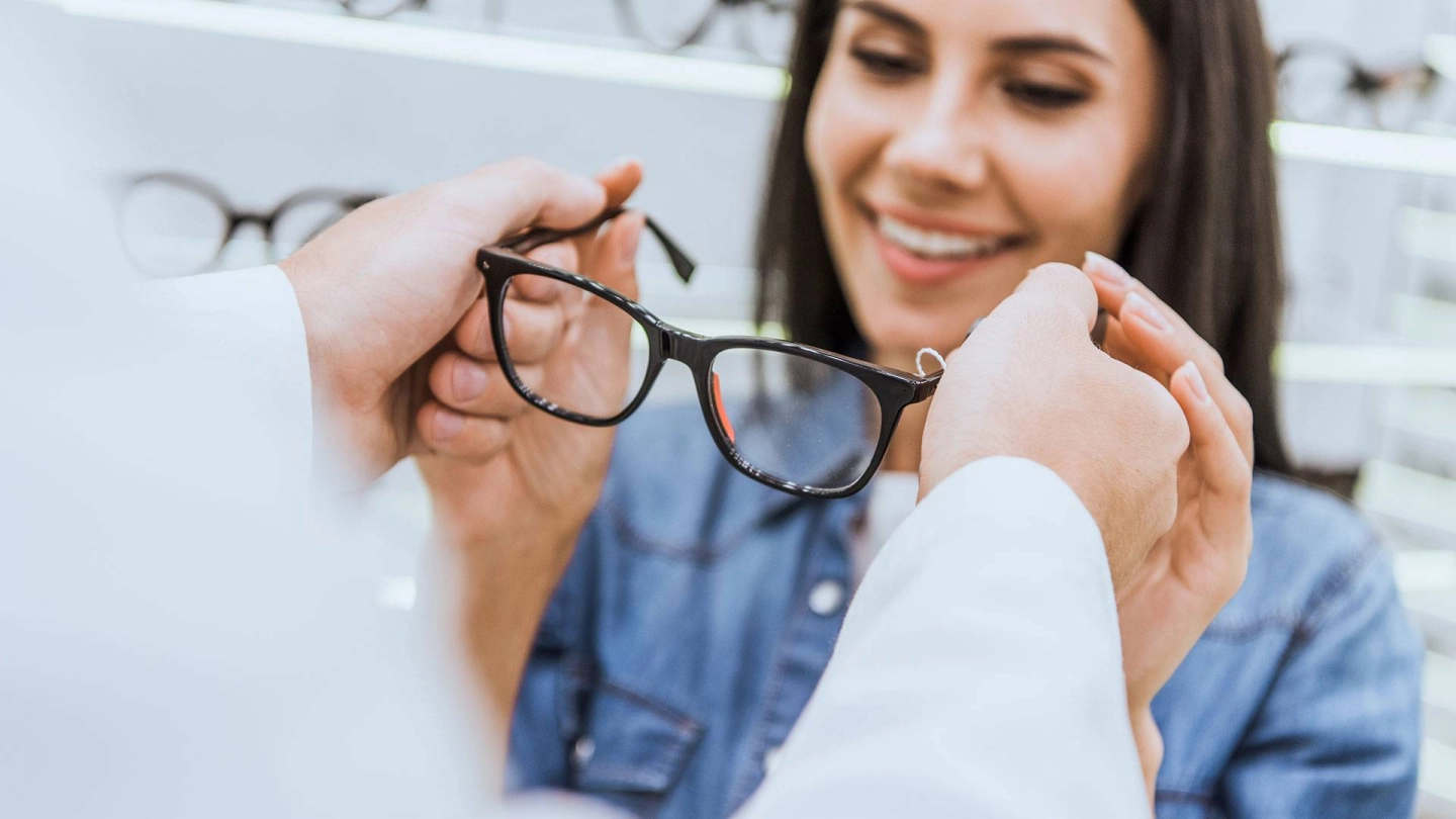 Junge Frau bekommt Brille vom Optiker