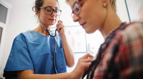 Ärztin hört das Herz einer Patientin ab