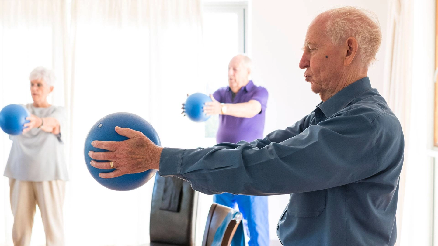Ein Mann hällt einen Medizinball